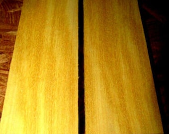May include: Two pieces of wood with a yellow-brown color and a wood grain pattern. The wood is smooth and appears to be unfinished.