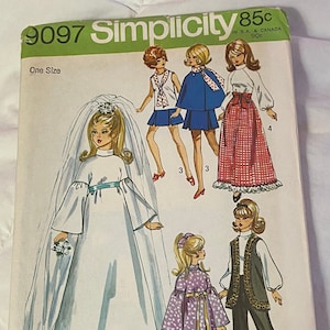 May include: A vintage Simplicity sewing pattern for doll clothes. The pattern includes five different outfits: a white bridal gown, a purple dress with white polka dots, a black vest with pants, a red and white gingham skirt, and a blue cape with a matching skirt. The pattern number is 9097 and the price is 85 cents.