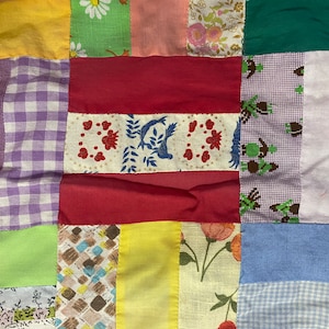 Puede incluir: Una colcha de retazos hecha de varias telas en diferentes colores y patrones, incluyendo verde, amarillo, rojo, azul y blanco.