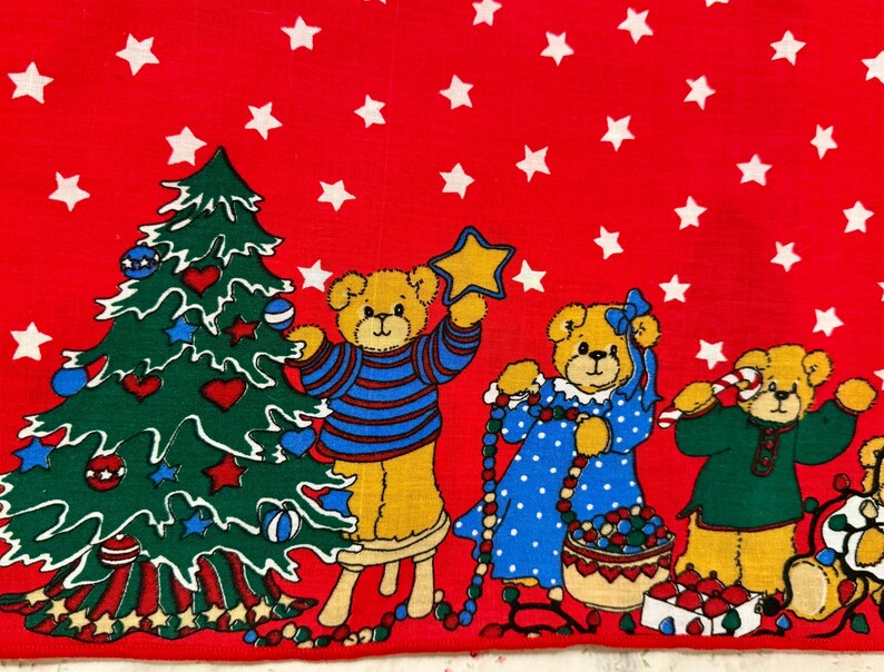 May include: A red Christmas-themed fabric featuring cartoon teddy bears and a decorated Christmas tree. The bears are dressed in festive attire, holding a star, a string of beads, and a candy cane. White stars are scattered across the red background.