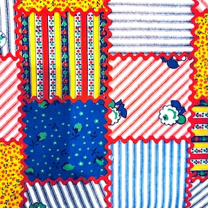 May include: A patchwork quilt with a variety of colorful patterns. The quilt features squares of yellow floral, red and white stripes, blue floral, and blue and white stripes, all bordered with a red zigzag trim.