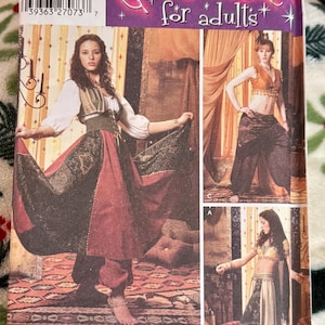 May include: Simplicity costume pattern for adults. The pattern features three costume designs with models wearing the outfits. The costumes include harem pants, tops, and skirts. The pattern includes the text "Costumes for adults".
