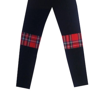 Peut inclure: Leggings noirs avec des empiècements en tartan rouge et noir au niveau des genoux.