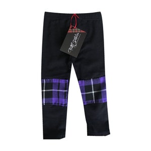 May include: Black leggings with purple and white tartan fabric panels at the knees. The leggings have a tag that reads "Pretty Patches".