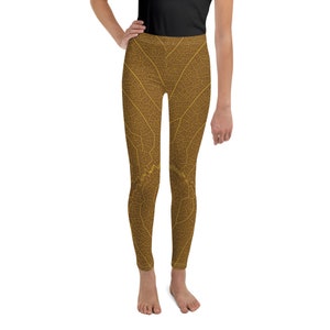 May include: Brown leggings with a leaf pattern. The pattern is a detailed outline of a leaf in a light yellow color.