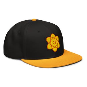 May include: A black and yellow baseball cap with an orange atom symbol embroidered on the front.