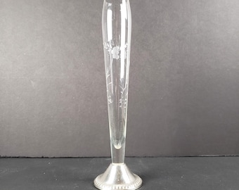 May include: A clear glass bud vase with an etched floral design and a silver base.