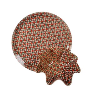 May include: A set of two brown and white ceramic dishes with a red floral pattern. The larger dish is round and the smaller dish is shaped like a flower.