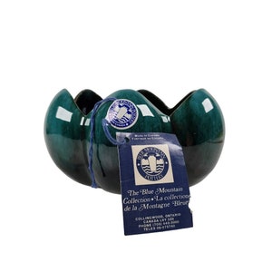 以下が含まれることがあります： 波打つ縁のある緑色の陶器のボウル。ボウルはブルー・マウンテン・ポタリー製で、ブルー・マウンテン・コレクションの一部です。タグには「カナダ製」と記載されています。