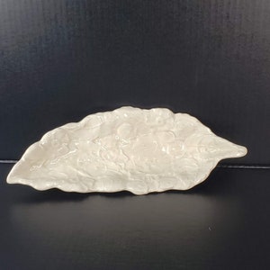 Może przedstawiać: Biała ceramiczna, liściasta tacka do serwowania z wypukłym wzorem liści i jagód.