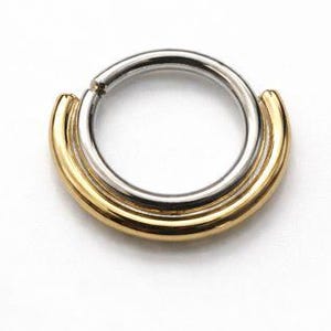 May include: A two-tone septum ring with a silver inner ring and a gold-colored outer band. The jewelry is circular with a hinged closure. The design is simple and modern, suitable for nose piercings.
