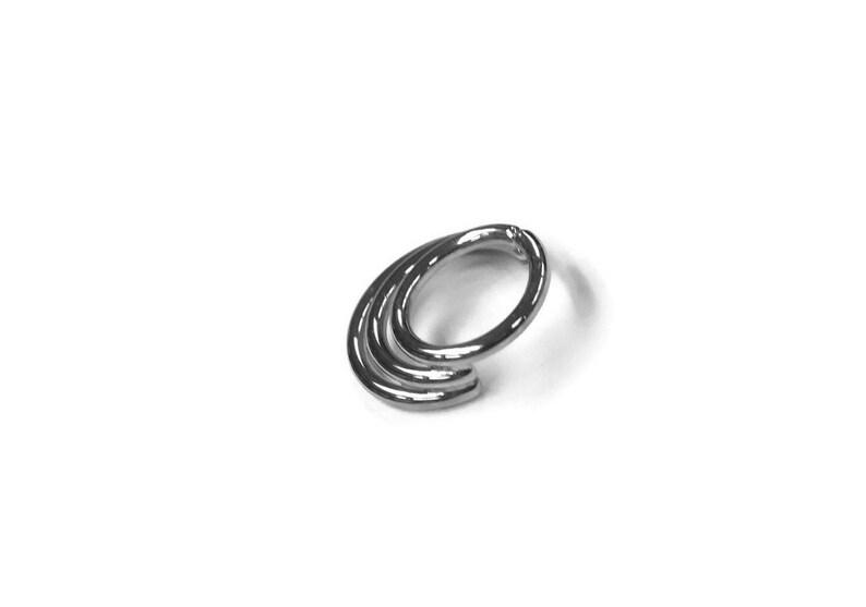 May include: Silver triple hoop nose ring. The hoop is made of three interlocking circles.