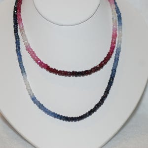 May include: A multi-colored gemstone necklace with a gradient of blue, pink, and red beads.