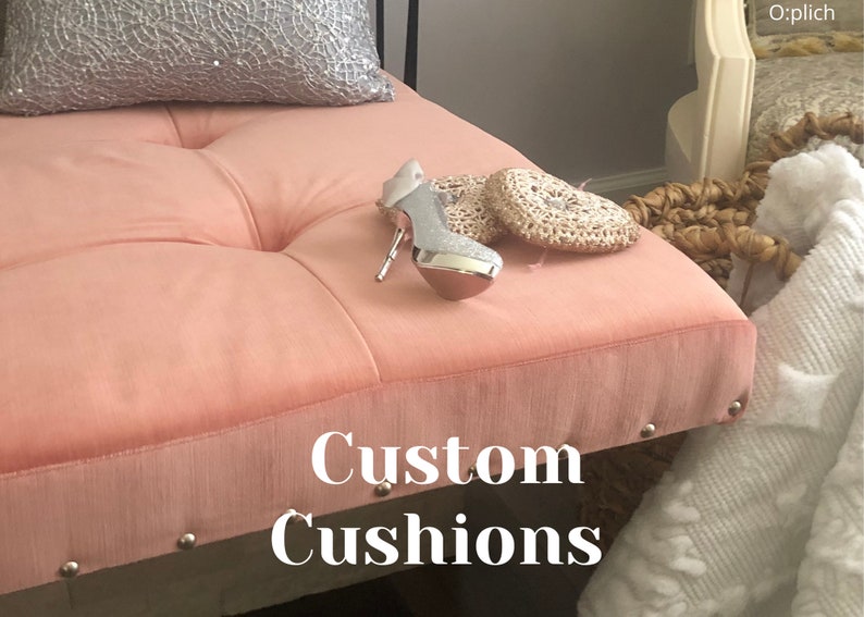 Puede incluir: Un banco de terciopelo rosa con cojines capiton&eacute; y ribete de tachuelas plateadas. El banco tiene un zapato de tac&oacute;n alto plateado y dos posavasos de coraz&oacute;n de ganchillo en la parte superior. El texto "Custom Cushions" est&aacute; impreso en el banco.
