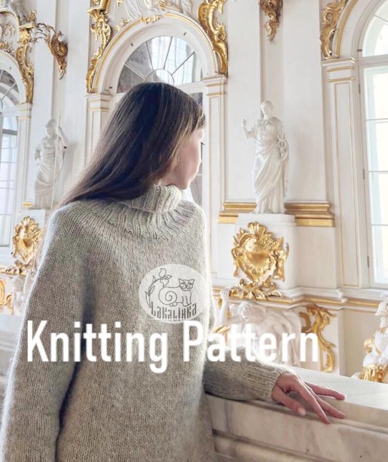 Puede incluir: Una persona con un su&eacute;ter de cuello alto gris claro con un parche blanco con una ilustraci&oacute;n de gato. El texto "Knitting Pattern" se muestra en blanco. El fondo incluye detalles arquitect&oacute;nicos ornamentados.