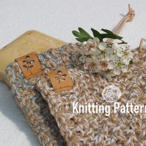 Könnte beinhalten: Ein handgemachtes Set aus Seife und gestricktem Seifenspender. Die Seife ist hellbraun und der Seifenspender besteht aus einem beige-weißen Strickmaterial. Der Seifenspender hat ein Lederetikett mit einem Blattdesign und eine Lederschlaufe.