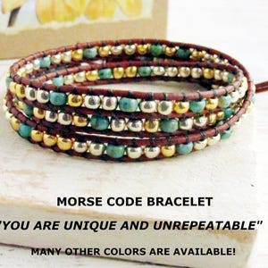 May include: Wrap bracelet with brown leather, turquoise, gold, and silver beads. The bracelet is wrapped multiple times. Text on the image reads "MORSE CODE BRACELET" and "YOU ARE UNIQUE AND UNREPEATABLE".