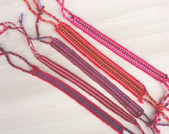 Armbanden met geweven draad 2 Educate, rode themaset 5, ontwerpen variëren, ingewikkeld handgeweven draad, fairtrade