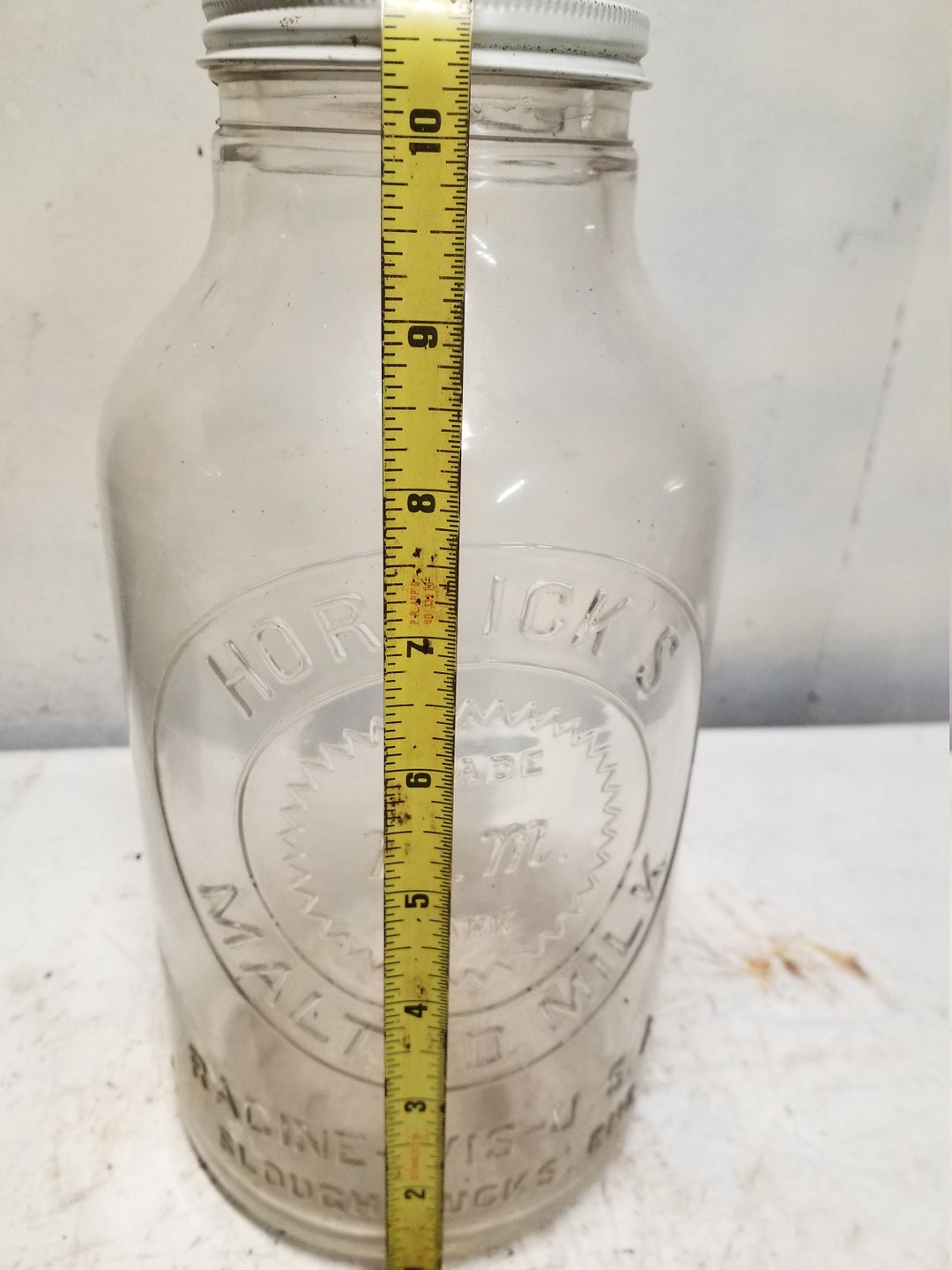 Havahart trap, knife, and vintage Horlick's malted milk bottle