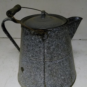 May include: A gray enamel camping coffee pot with a wooden handle and a lid. The pot has a speckled gray and white finish.
