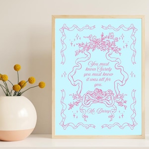 Puede incluir: Una impresión artística enmarcada con un fondo azul claro y un diseño floral y de cinta rosa. El texto dice: "You must know. Surely you must know it was all for you. Mr. Darcy." Una flor amarilla y un jarrón a la derecha.