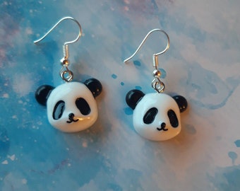 Könnte beinhalten: Ein Paar silberne Ohrhänger mit einem niedlichen Pandabären-Anhänger. Die Pandas sind weiß mit schwarzen Augen, Ohren und Nase.