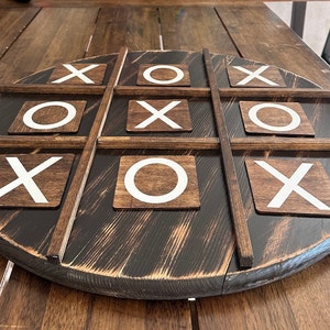 May include: A wooden tic-tac-toe game with white X's and O's on brown squares.