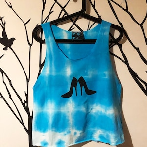 May include: A blue tie-dye tank top with a white design of two high-heeled shoes.