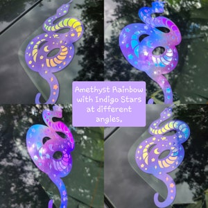 Pode incluir: Quatro imagens de um adesivo hologr&aacute;fico de uma cobra com estrelas e luas. A cobra &eacute; de cor roxo claro com um acabamento arco-&iacute;ris iridescente. As estrelas s&atilde;o azul &iacute;ndigo com um acabamento arco-&iacute;ris iridescente. As luas s&atilde;o brancas com um acabamento arco-&iacute;ris iridescente. O adesivo &eacute; mostrado em diferentes &acirc;ngulos para mostrar o acabamento iridescente.