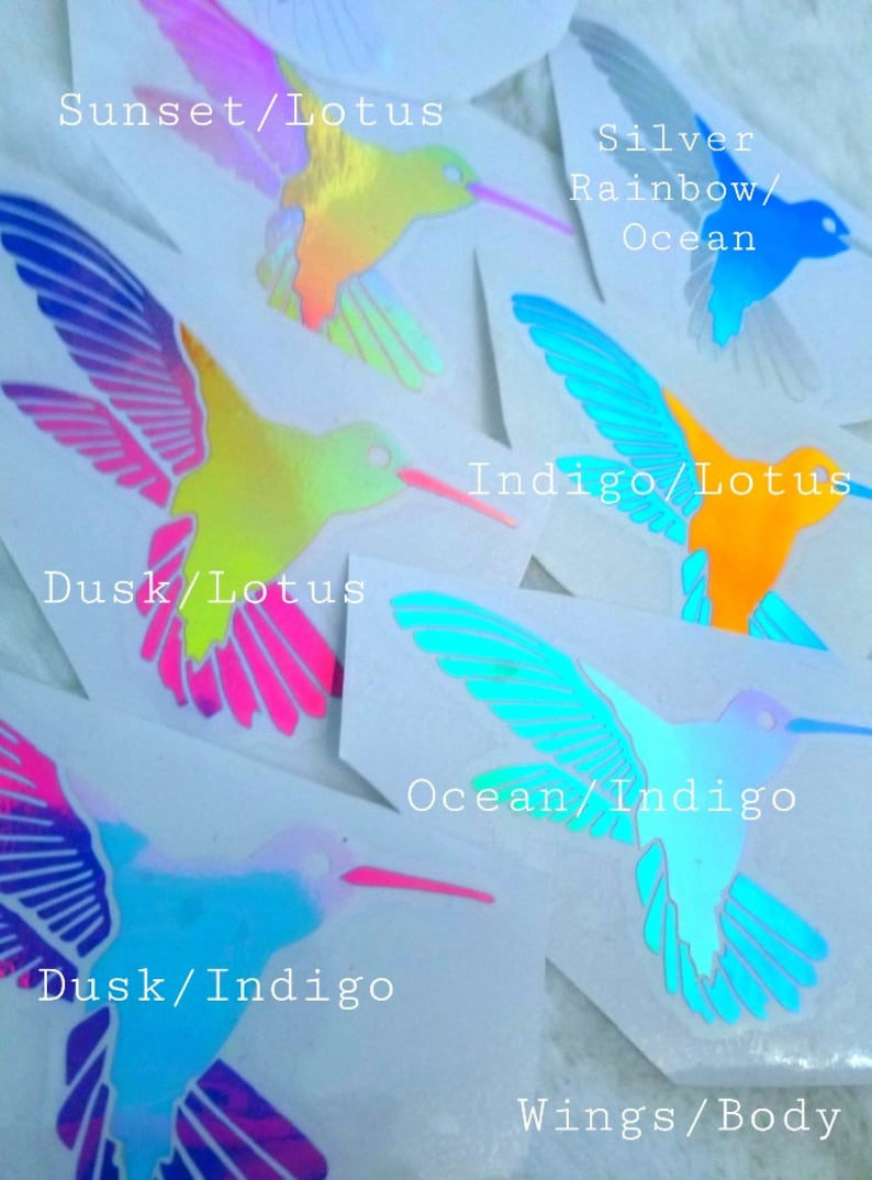 May include: Hummingbird stickers with iridescent finishes in various color combinations. The stickers feature the text "Sunset/Lotus", "Silver Rainbow/Ocean", "Indigo/Lotus", "Dusk/Lotus", "Dusk/Indigo", "Ocean/Indigo", and "Wings/Body".