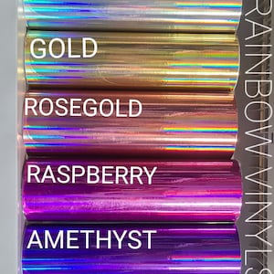 May include: A selection of colorful vinyl rolls, each labeled with a color name. Colors include black, silver, gold, rose gold, raspberry, amethyst, and teal. The text "RAINBOW VINYLS" is visible on the right side.