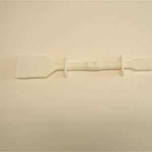 Peut inclure: Un grattoir en plastique blanc avec une longue poign&eacute;e et une lame rectangulaire. Le grattoir est utilis&eacute; pour enlever les adh&eacute;sifs, la peinture et autres mat&eacute;riaux.