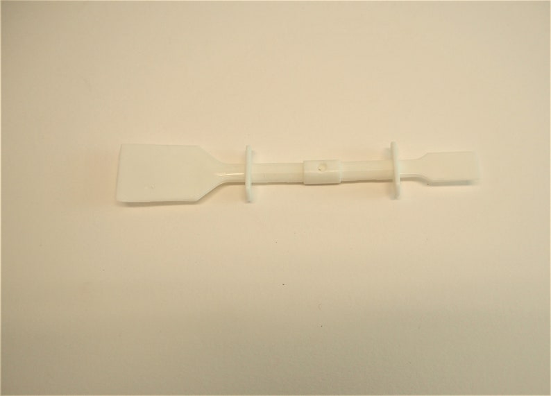 Peut inclure: Un grattoir en plastique blanc avec une longue poign&eacute;e et une lame rectangulaire. Le grattoir est utilis&eacute; pour enlever les adh&eacute;sifs, la peinture et autres mat&eacute;riaux.