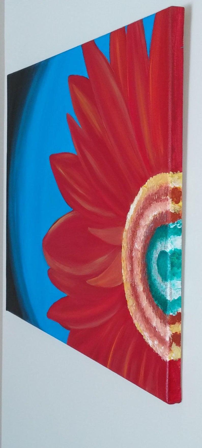 May include: A red flower with a yellow center and a teal blue and white swirl in the center. The flower is painted on a blue background.