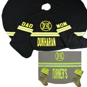 May include: A black Christmas tree skirt and two matching stockings featuring yellow firefighter-themed graphics, including the letters FD, the word DAD, the word MOM, and the name DUKHARAN. A second set in tan features the name TURNER'S and ANTHONY.