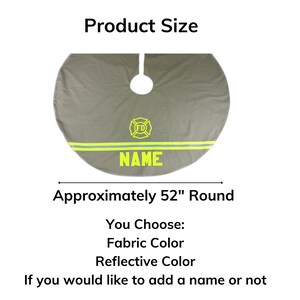 May include: A round gray tree skirt measuring approximately 52 inches in diameter. It features a yellow firefighter emblem with the letters FD and two horizontal reflective stripes. The word NAME is printed in yellow below the stripes.