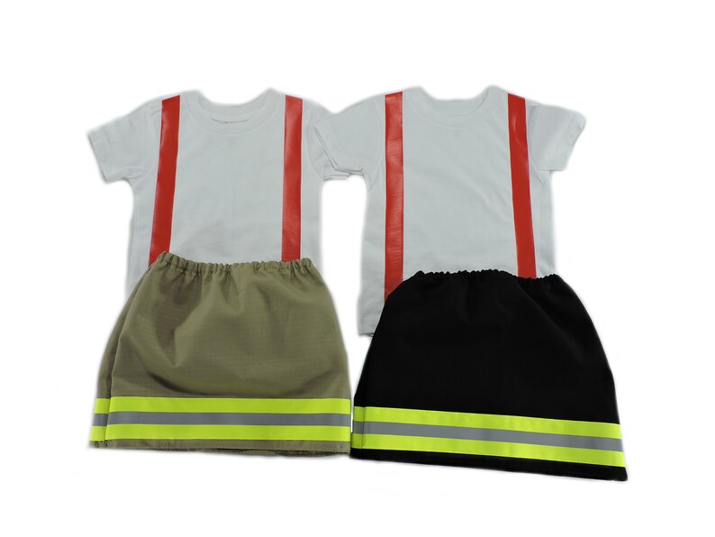 May include: Two firefighter costumes for kids. Each costume includes a white t-shirt with red stripes and a skirt with yellow reflective tape. One skirt is khaki and the other is black.