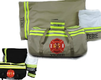 May include: A tan duffel bag, pillowcase, and towel set featuring yellow reflective stripes and a red Fire Dept emblem with the name TEBIE. A smaller black duffel bag, pillowcase, and towel set with the name WRIGHT are also displayed.