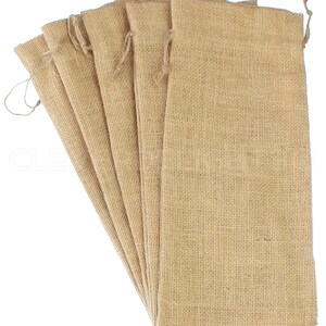 May include: A set of six natural brown burlap bags with drawstrings. The bags are made of a coarse woven fabric and are perfect for packaging gifts or small items.