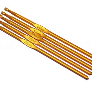 May include: Set of five gold crochet hooks, each with a different size marked in millimeters: 2.50mm, 3.50mm, 4.50mm, 5.50mm, and 6.50mm.
