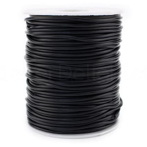 May include: A spool of black elastic cord, wound tightly on a white plastic spool.