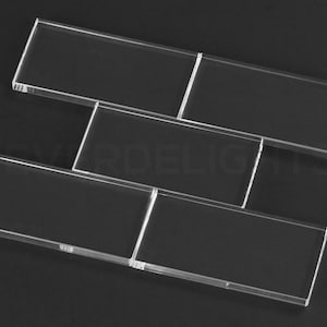 May include: Four clear glass tiles arranged in a staggered pattern, creating a geometric design.
