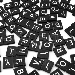 May include: Black letter tiles with white letters on them are scattered on a white surface. The letters include A, B, C, D, E, F, G, H, I, J, K, L, M, N, O, P, Q, R, S, T, U, V, W, X, Y, and Z. Some tiles have numbers on them.