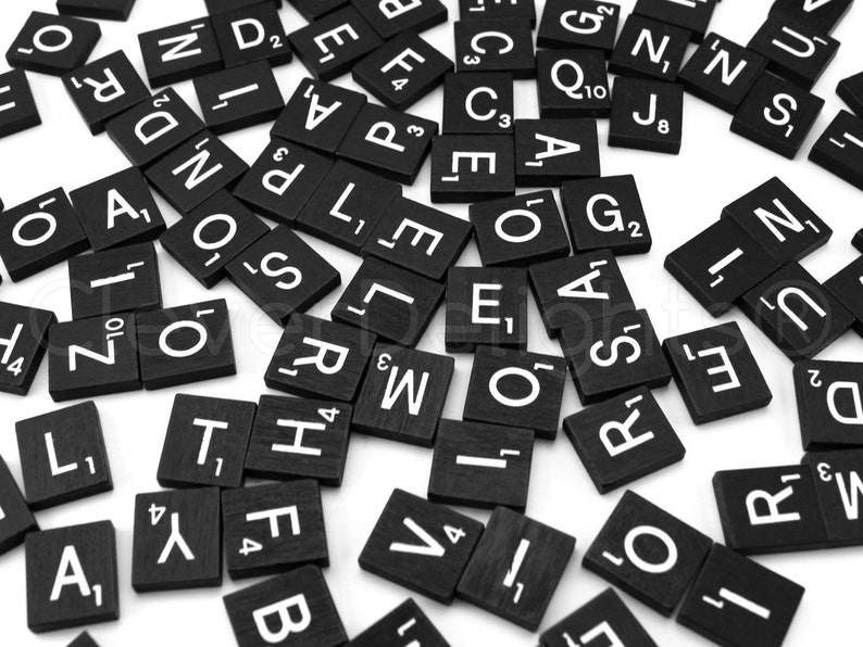 May include: Black letter tiles with white letters on them are scattered on a white surface. The letters include A, B, C, D, E, F, G, H, I, J, K, L, M, N, O, P, Q, R, S, T, U, V, W, X, Y, and Z. Some tiles have numbers on them.