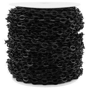 May include: A continuous length of glossy black metal chain wrapped around a white cylindrical spool. The chain consists of uniform, interlocking oval-shaped links that create a dense, textured appearance across the entire surface of the spool.