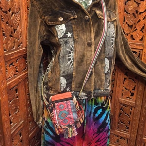 Pode incluir: Uma jaqueta de veludo marrom com um design de patchwork colorido e uma pequena bolsa transversal colorida com franjas. A jaqueta tem um fecho de correr e um fecho de bot&otilde;es na frente. A bolsa tem um fecho de correr e uma aba com um fecho de bot&atilde;o.