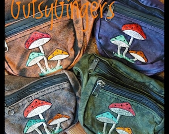 Pode incluir: Quatro pochetes em tons de castanho, azul e verde, cada uma com um fecho de correr preto e um desenho de cogumelo bordado. O texto "Gutsyfingers" está escrito em laranja no topo.