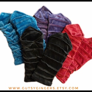 May include: A collection of colorful, textured fabric sleeves in shades of blue, purple, black, and red. Each sleeve has horizontal stitched lines. The website address www.gutsygingers.etsy.com is visible at the bottom.