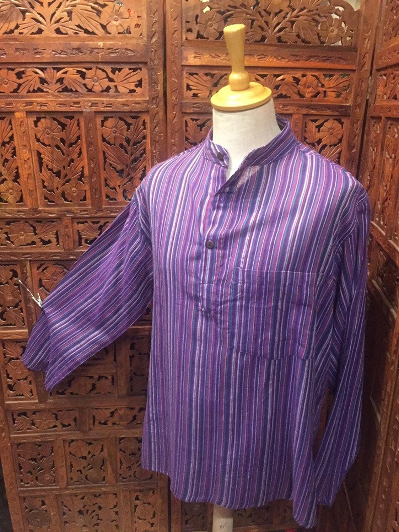 May include: A long-sleeved, purple and white striped shirt with a mandarin collar and a single button closure. The shirt has a pocket on the left side.