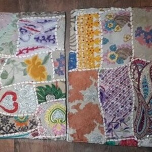 May include: Two square patchwork cushions with a variety of colorful fabrics and embroidery. The cushions are made from a mix of materials, including velvet, cotton, and silk. The cushions are decorated with beads, sequins, and other embellishments.